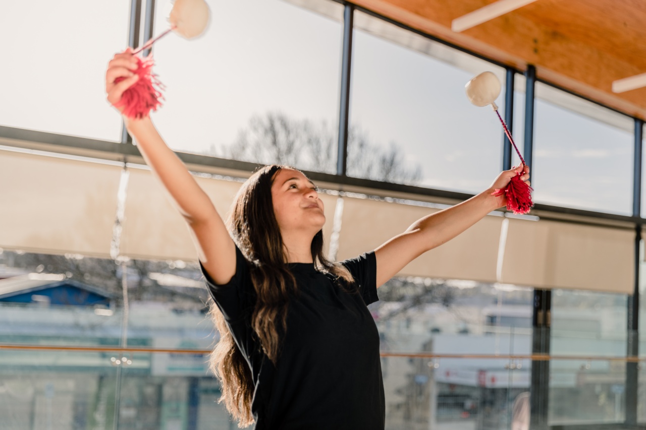 A young Maori woman dancing with two poi in her hands