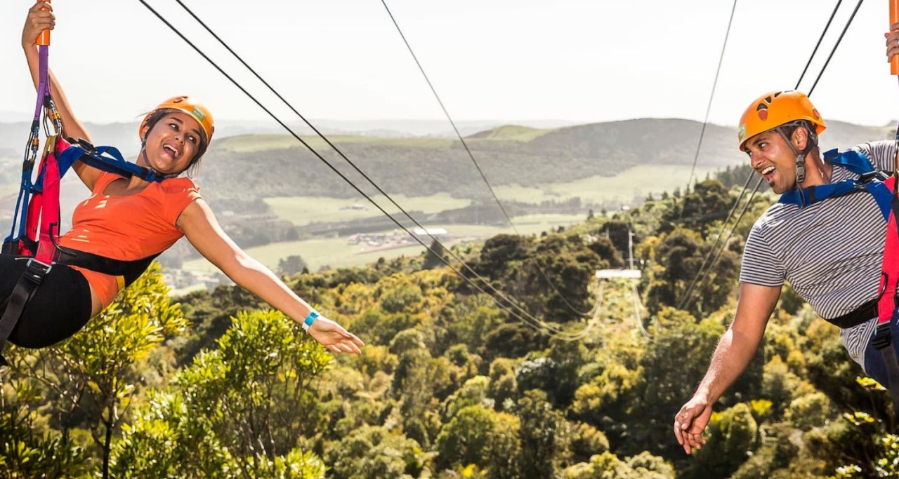 Two people on a zipline over treetops with EcoZip Adventures